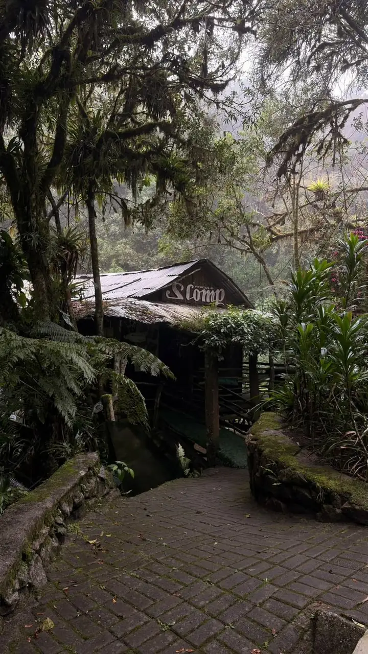 Entrada do restaurante, construção rústica de madeira em meio à mata