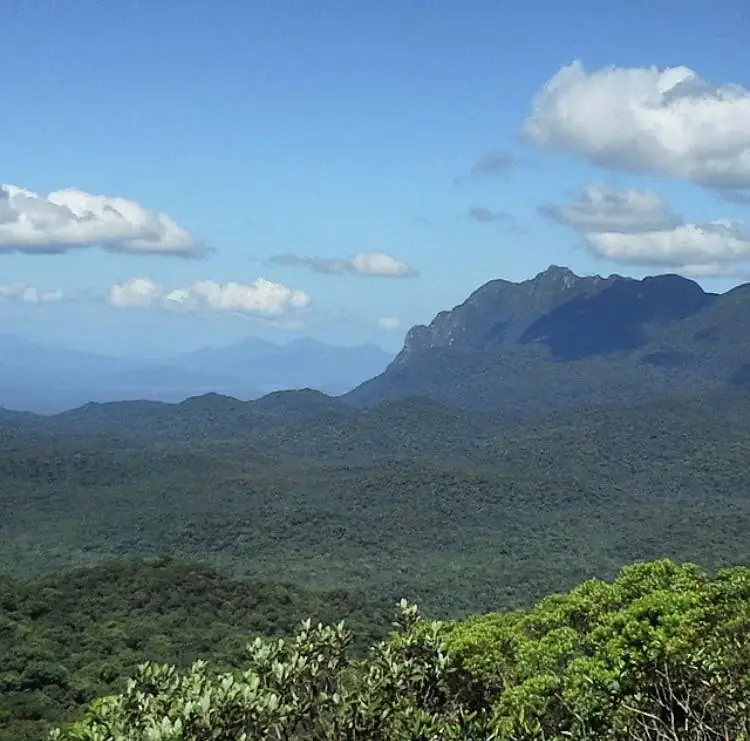 Serra coberta de mata sob céu azul com nuvens
